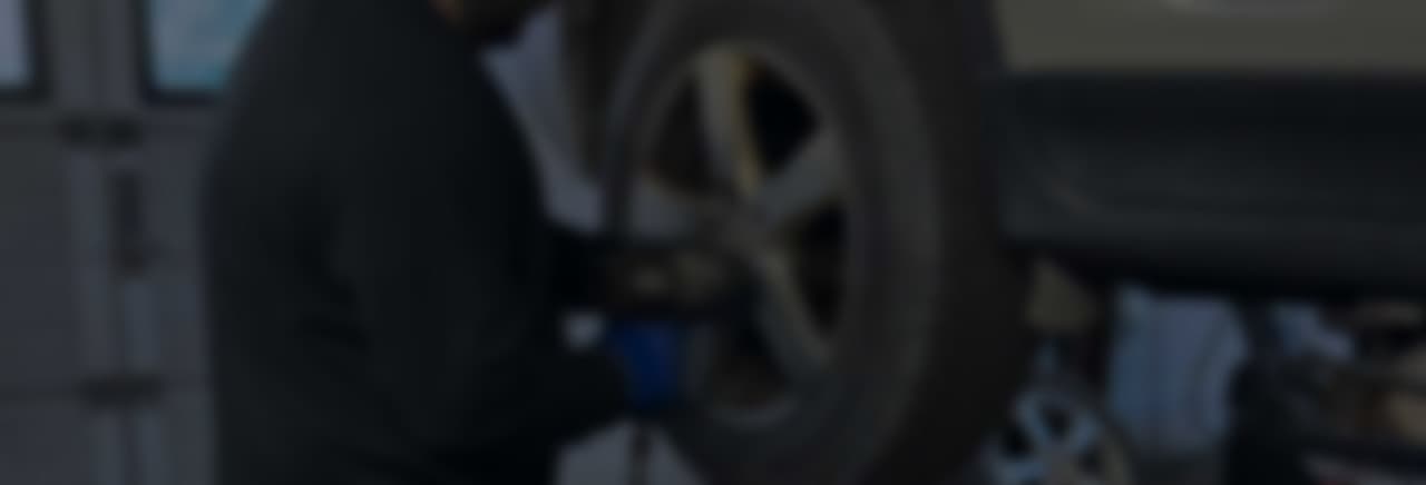 Mechanic inspecting a white car in a professional workshop